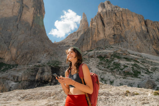 istock Cheerful woman using smartphone while hiking in Dolomites 2151310822