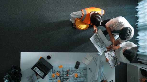 istock Top view of engineer hold laptop while explain idea to architect. Alimentation. 2151312506