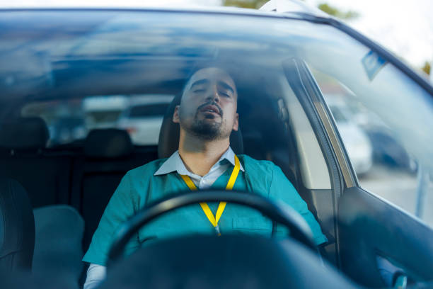 Despite feeling tired, a male doctor remains focused behind the wheel, his commitment to safety as paramount as his dedication to his patients, showcasing his resilience