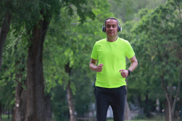 istock Mature sport man jogging in public park 2151327328
