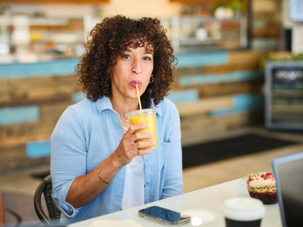 istock Happy Woman With a Smoothie in a Small Cafe 2151328350