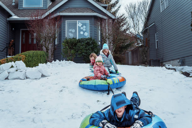 Group of children sled down a snowy hill