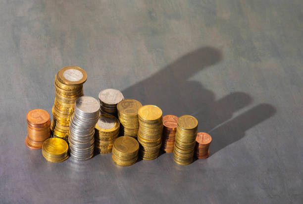 istock Golden coins stacks on bright light glowing bokeh background 2151335773