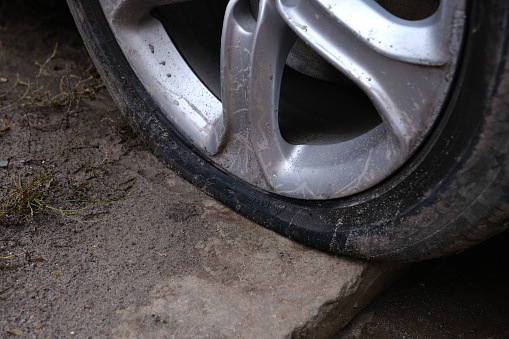 car flat tire. deflated wheel of a car with alloy disk.