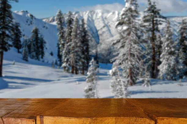 Empty rustic wooden table for product display with blurred snowy winter landscape on the background