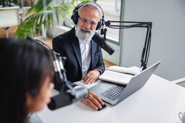 istock Senior Male Podcaster Interviewing Black Female Colleague 2151346049