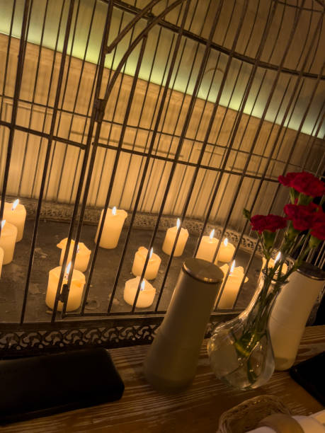 istock Carnation flowers in a vase and candles on a table in a restaurant 2151346324