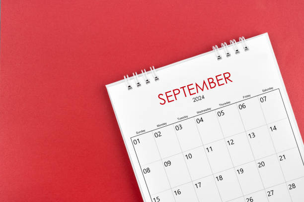 September 2024 desk calendar on red background.