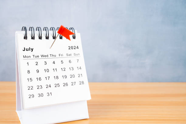 istock July 2024 calendar and red push pin on the table. 2151347203