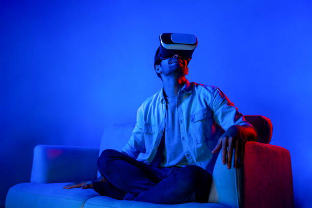 istock Happy man sitting at sofa while wearing VR goggle to watch movie. Deviation. 2151349052