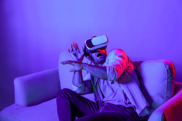 istock Scared person watching at horror movie by using VR goggles at sofa. Deviation. 2151351751