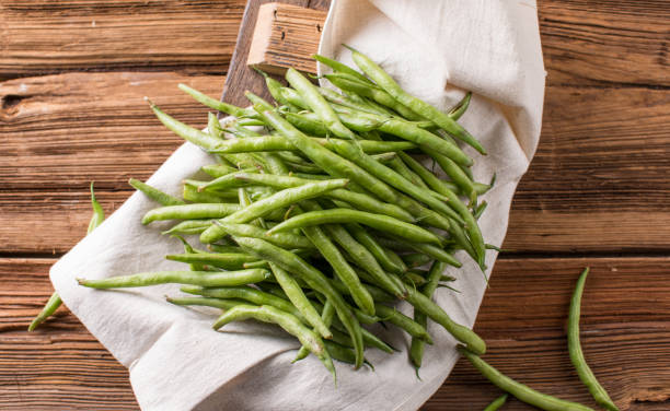 istock Fresh young beans pods. Old wooden background. Green string beans crop conception 2151352097