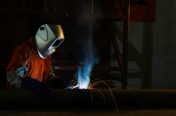 istock Handymen performing welding and grinding at their workplace in the workshop, while the sparks fly all around them, they wear a protective helmet and equipment. 2151355749