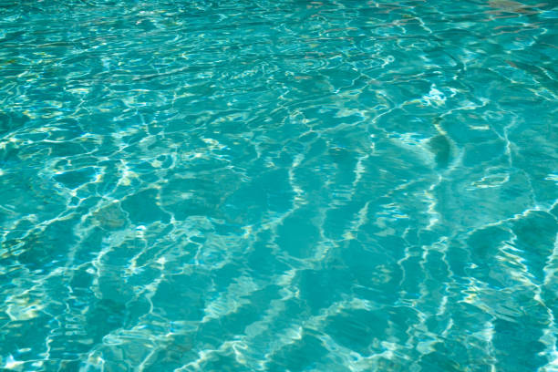 Turquoise water pool surface reflection ripples at swimming pool in sunlight