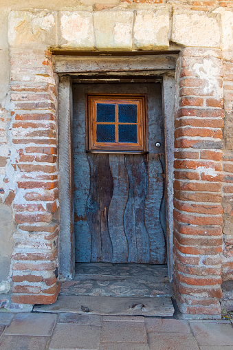 Very old and worn wooden door in adobe brick bulding.