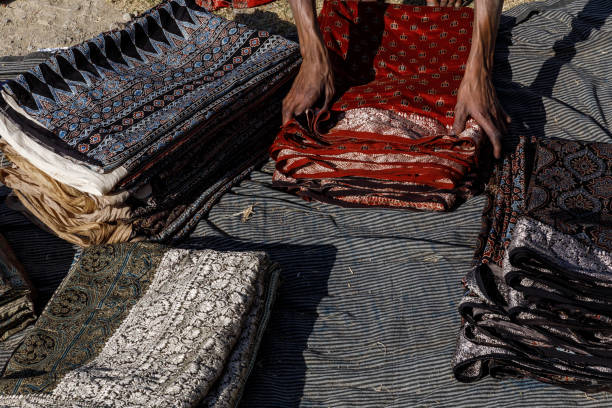 worker putting together wood stamped colorful textiles