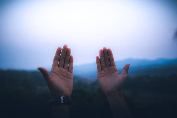 istock Man raised both hands up pray for blessings to God. 2151363868