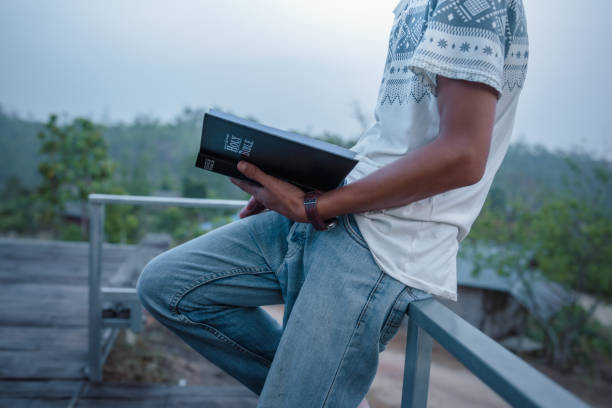 istock Young man standing holding and reading. christian concept. 2151363870