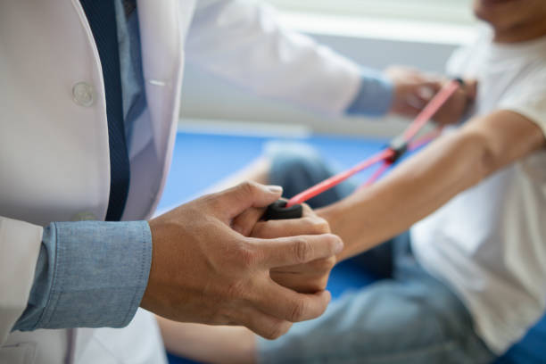 doctor is examining muscle injury and using elastic bands test injury and also help with physical therapy strengthen muscles because physical therapy will help strengthen muscles and help blood flow.