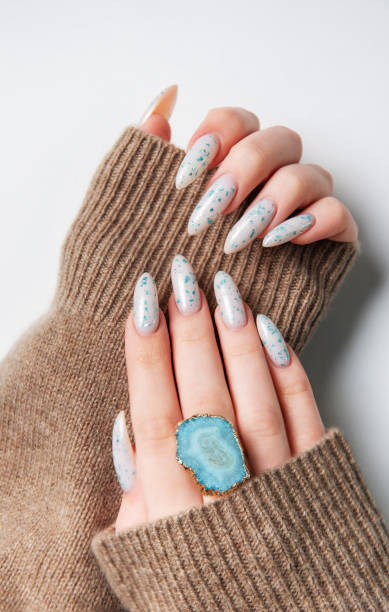 istock Hands with blue nail polish on cozy sweater 2151371577