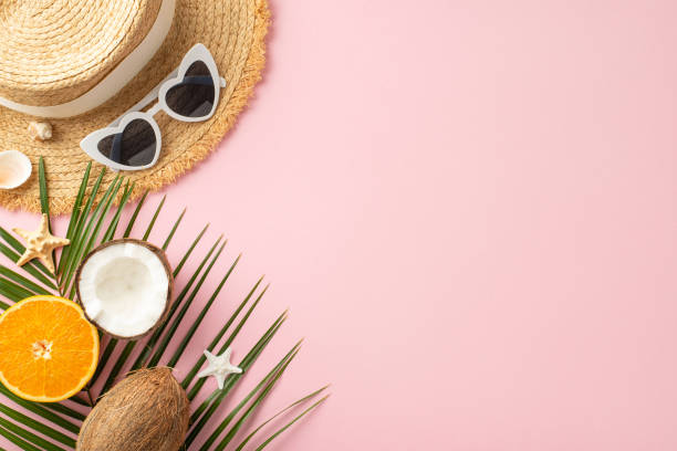 istock A creative layout featuring summer vacation essentials such as a straw hat, sunglasses, coconut, and orange on a vibrant pink background, perfect for travel promotion 2151372308