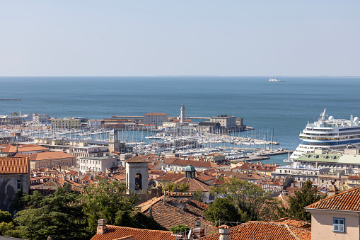 Trieste, Italy - September 26, 2023: Aerial view from San Giusto Hill of city and coast of sea, port for ships