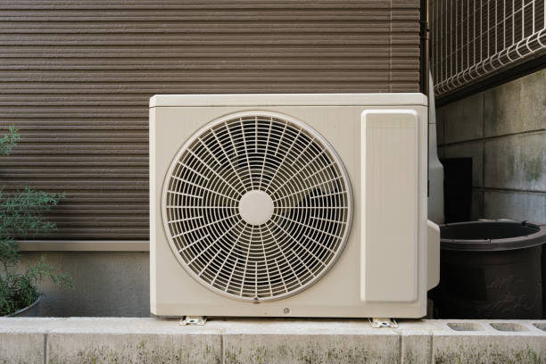A square metal air conditioning unit on the outside wall of a building.
