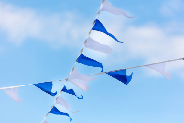 istock Festive blue white flags against the sky with clouds 2151381236