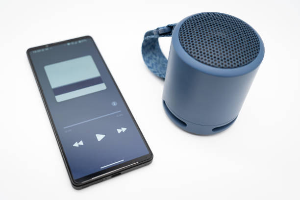 istock Portable wireless blue speaker with smartphone isolated on white background. 2151382953