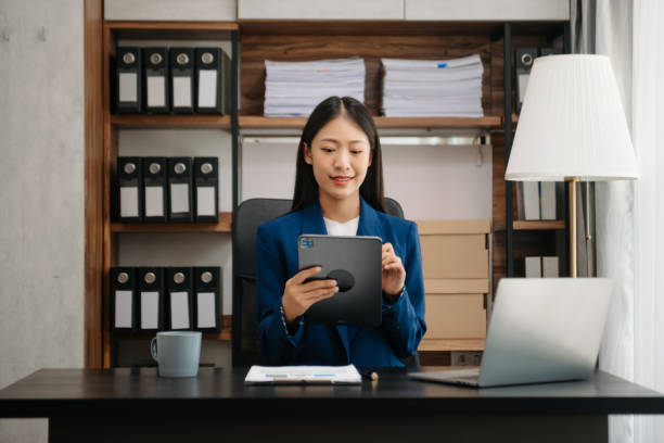 istock Woman freelancer is working her job on computer tablet and laptop Doing accounting analysis report real estate investment data, Financial 2151383386