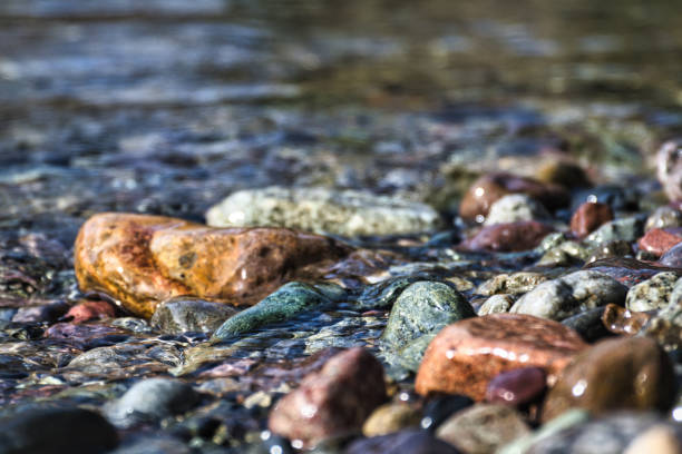 Siola - France. March 19, 2024. Close-up view of colorful pebbles lining the bottom of a mountain stream in Corsica.