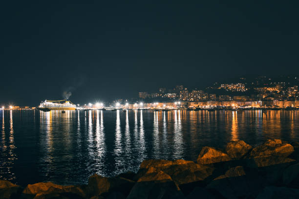 Ajaccio - France. March 19, 2024. View of the bay of Ajaccio at night with the reflection of the city lights and boats in the Mediterranean sea