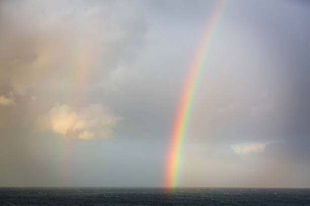 Rainbow on a dark horizon with subtle clouds