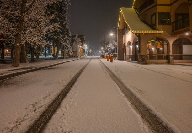 Early morning tire tracks on a snow-covered street in Canmore, Alberta, Canada
