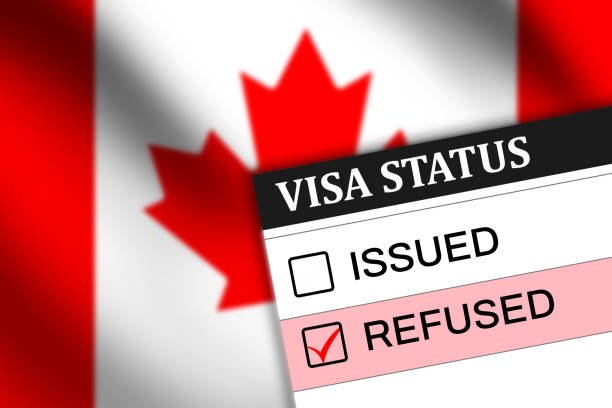 istock Canada visa refused status on paper with red tick mark in the box and waving flag in the backdrop 2151396720