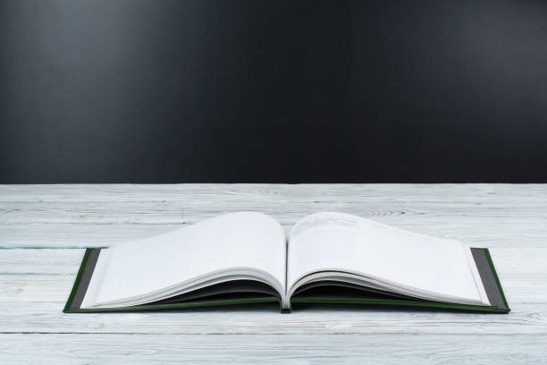 istock Open book on wooden deck table and black board background. Back to School. Education concept with copy space for your ad text. 2151397135