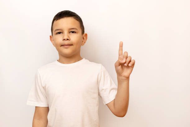 A joyful 3 year old boy proudly displays their dirty, paint-covered fingers after a creative painting activity at home. The image captures the innocence, fun, and messiness of childhood art projects.