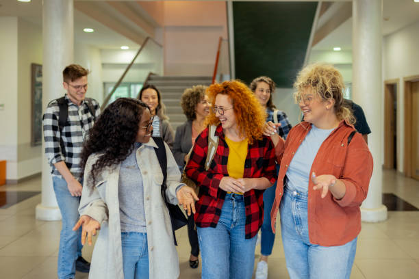 istock Smiling Diverse College Students in School Corridor Talking After Lecture 2151403516