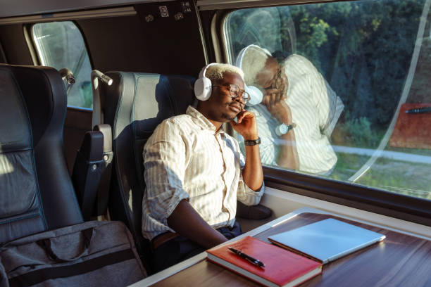 African American young man sitting on the seat near window and sleeping in train