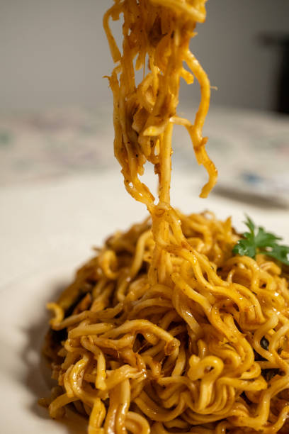 cooking instant noodle on metal plate in macro shot