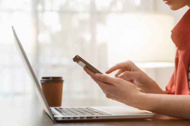 istock Woman hand using smartphone with digital laptop on the table in office. 2151408718