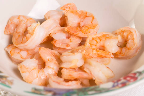 Rice with sun-dried tomatoes and shrimp, close-up on fork and serving plate