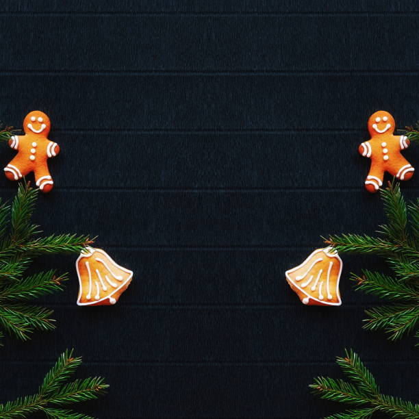 istock Symmetrical New Year's composition. Gingerbread, Christmas tree branches and candles are on a background of dark paper. Layout for the design. A place for the text. Flat Lay. Top View 2151420142