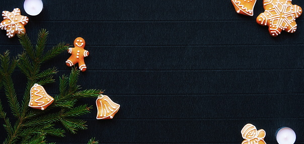 Gingerbread and Christmas tree branches on a dark paper craft background. Happy New Year Conception