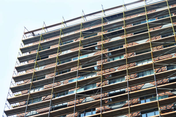 istock High-rise modern multi-apartment residential building under construction with scaffolding and decorative safety net. 2151422856
