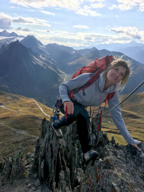 istock Young woman climbs with rope in mountains 2151425001
