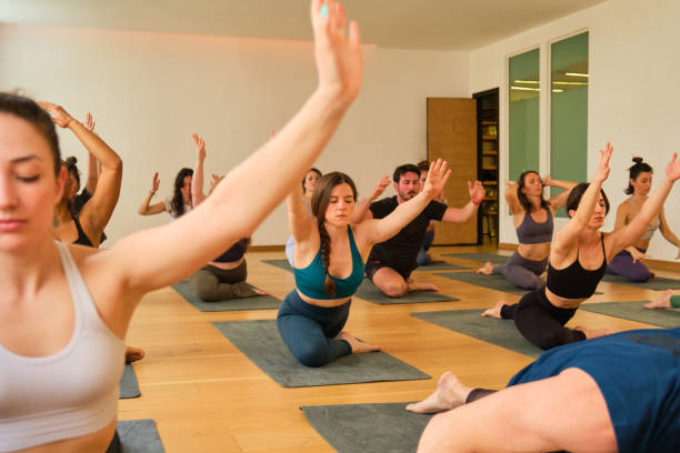 istock A large group of people are practicing yoga in a room. 2151425632