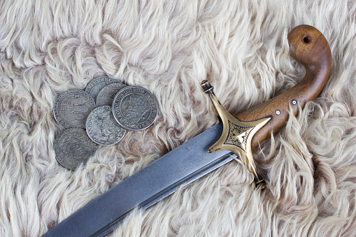 Ukraine Saber Sword with silver taller coins on fur background, 17th century. Poland, Lithuania, Hungary, Ukraine.