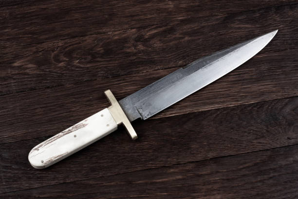 istock Old west bowie knife on wooden deck 2151426877