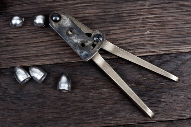Antique old west bullet mold with bullets for revolver. Isolated on white background.